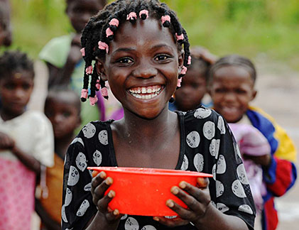 Mädchen mit roter Schüssel in Afrika.